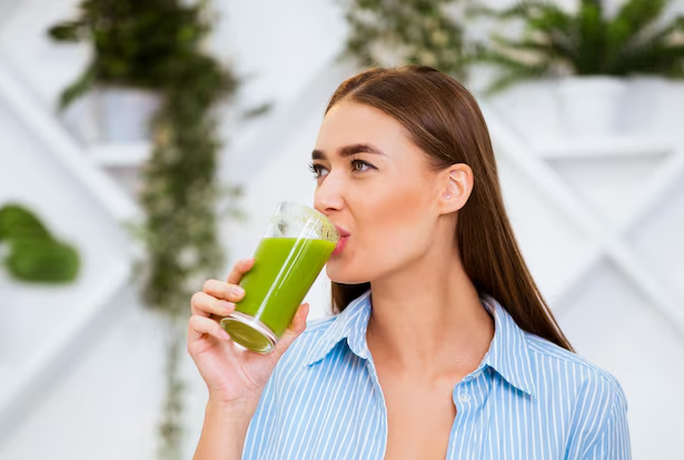 mujer tomando jugo verde